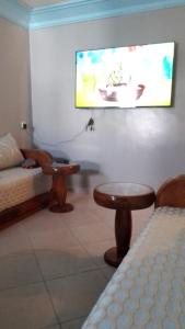 a living room with a bed and a tv on the wall at appartement pour famille in Agadir