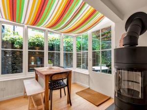 a room with a table with a colorful curtain over it at Pass the Keys Stunning Open Plan Home in City in Canterbury