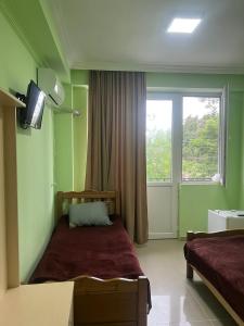 a bedroom with a bed and a tv and a window at Hotel Lotus in Ureki