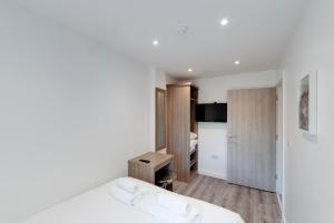 a bedroom with a bed and a desk and a television at Liverpool Short Stay Apartments in Liverpool