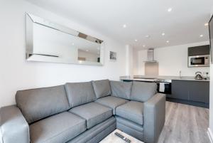 a living room with a couch and a kitchen at Liverpool Short Stay Apartments in Liverpool