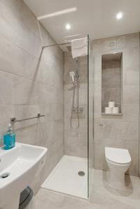 uma casa de banho com um chuveiro, um WC e um lavatório. em Liverpool Short Stay Apartments em Liverpool