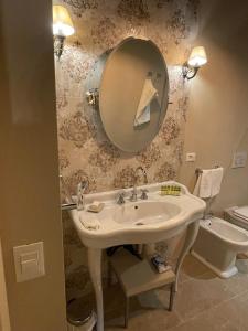 a bathroom with a sink and a mirror and a toilet at La Bohème in Lucca