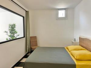 ein Schlafzimmer mit einem Bett und einem Fenster in der Unterkunft Appartement avec vue sur le port in Sète