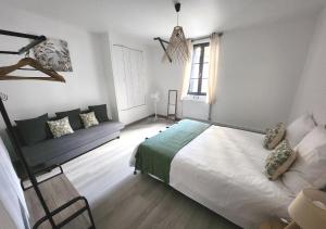 a bedroom with a bed and a couch in it at "Cozy Zen" 1 grande chambre - Calme - Arrivée autonome - 6 pers - Parking gratuit in Tours