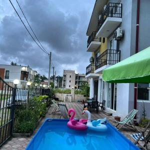 two pink swans in a swimming pool in front of a building at Hotel Lotus in Ureki