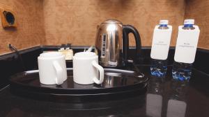 a tray with two coffee mugs and a tea kettle at InterContinental Almaty, an IHG Hotel in Almaty