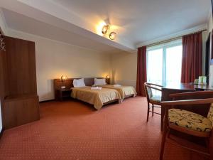 シビウにあるCasa Manuのベッドとデスクが備わるホテルルームです。