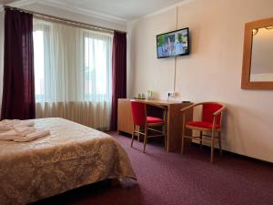 a hotel room with a bed and a table and chairs at Casa Manu in Sibiu