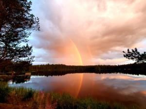 un arco iris sobre un lago con un cielo nublado en Saunatupa, en Syöte