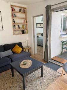 een woonkamer met een blauwe bank en een tafel bij Maison cosy rénovée avec jardin in Rouen