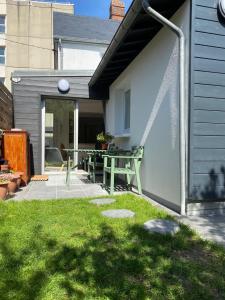 - une terrasse avec une table de pique-nique dans l'arrière-cour dans l'établissement Maison cosy rénovée avec jardin, à Rouen