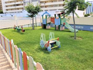 einen Spielplatz mit Spielausrüstung auf dem Rasen in der Unterkunft Gemelos 22-3-12 in Benidorm