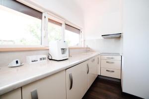 a white kitchen with a sink and a window at Hotel Antonio in Uzhhorod