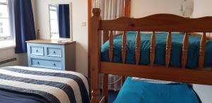 a bedroom with a bunk bed and a blue dresser at Rose Court Holiday Apartments in Torquay