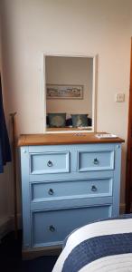 a blue dresser with a mirror on top of it at Rose Court Holiday Apartments in Torquay