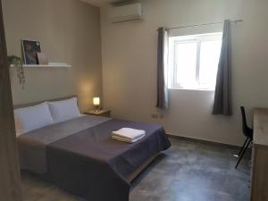 una camera da letto con un letto e due asciugamani di No. 38 Appartments a Sliema