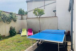 een tafeltennistafel en 2 stoelen in de achtertuin bij Spacious house with garden in La Rochelle