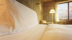 a bedroom with a large white bed and a window at InterContinental Almaty, an IHG Hotel in Almaty