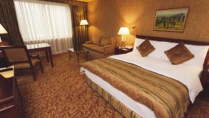 a hotel room with a large bed and a chair at InterContinental Almaty by IHG in Almaty
