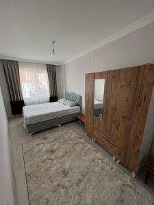 1 dormitorio con 1 cama y un gran armario de madera en Balkonlu Lüks Eşyalı Aile Evi, en Sinope