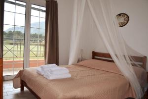 Un dormitorio con una cama con toallas blancas. en Seaside Villa, en Káto Vasilikí