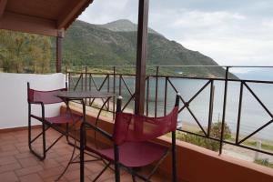 a balcony with two chairs and a table and a view of the water at Seaside Villa in Káto Vasilikí