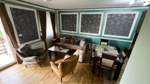a living room with a couch and a table and chairs at Apartments 24&26 in Žabljak