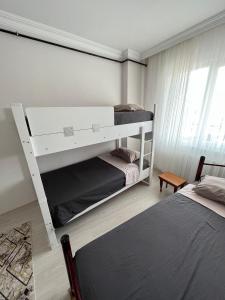 1 dormitorio con 2 literas y ventana en Balkonlu Lüks Eşyalı Aile Evi, en Sinope