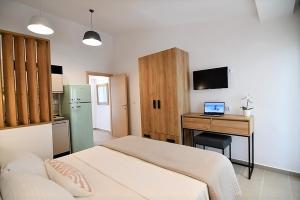 een slaapkamer met een bed en een bureau met een laptop bij Villa Foni in Pefkochori