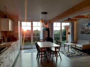 een keuken en eetkamer met een tafel en stoelen bij Annemarie Zerpenschleuse - Schwedenhaus mit Künstler-Charme und Sauna in Zerpenschleuse