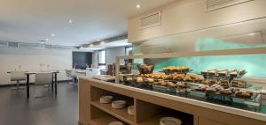 a restaurant with a display case with food in it at Ilunion Almirante in Barcelona +21 photos