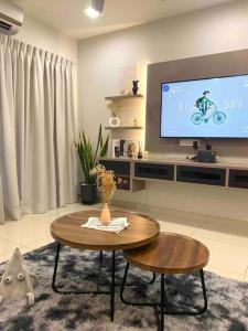 a living room with a table and a tv at Stylish Cozy House Near Ipoh Lost World Tambun in Kampong Batu Lapan