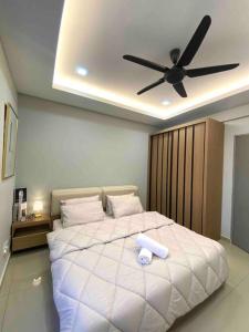 een slaapkamer met een groot wit bed en een plafondventilator bij Stylish Cozy House Near Ipoh Lost World Tambun in Kampong Batu Lapan