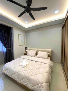 een slaapkamer met een wit bed en een plafondventilator bij Stylish Cozy House Near Ipoh Lost World Tambun in Kampong Batu Lapan