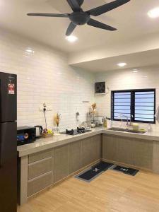 a kitchen with a ceiling fan in a kitchen at Stylish Cozy House Near Ipoh Lost World Tambun in Kampong Batu Lapan