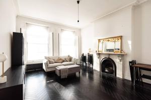 a living room with a couch and a fireplace at Stunning Flat in Highbury Hill in London
