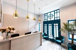 a waiting room with blue chairs and a reception desk at NOX Richmond in Richmond