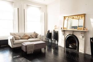 a living room with a white couch and a fireplace at Stunning Flat in Highbury Hill in London