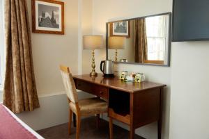 イーリーにあるLamb Hotel by Greene King Innsの鏡と椅子付きのホテルルームのデスク