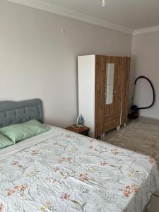 Schlafzimmer mit einem Bett und einem Holzschrank in der Unterkunft Balkonlu Lüks Eşyalı Aile Evi in Sinop