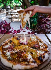 a person is holding a slice of pizza at Sheriff, Olympos in Kumluca