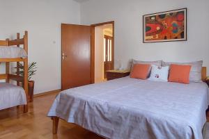 1 dormitorio con 1 cama grande con almohadas de color naranja y gris en Sea View Karst House Apartment with Bikes, en Komen