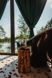 a person sitting at a table with two glasses of wine at Dom nad jeziorem Mazury - Pod Napięciem in Mrągowo