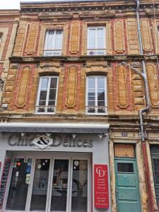 un vieux bâtiment en briques avec des fenêtres sur une rue dans l'établissement Le Zen & Cosy*Hyper centre, à Charleville-Mézières