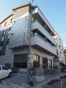 安塔利亞的住宿－ZENİA OTEL，前面有停车位的建筑