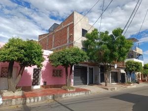 um edifício cor-de-rosa ao lado de uma rua em Apto 202 em Cúcuta