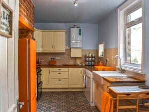 a kitchen with white cabinets and a sink at Castle View in Scarborough