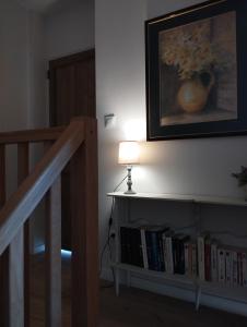 a lamp on a table next to a book shelf with books at Le Clos des Mouettes in Calais