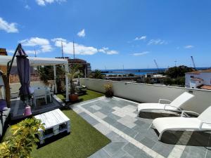 balcón con muebles blancos y vistas al océano en Terraza del Atlántico, un oasis en la ciudad, en Santa Cruz de Tenerife